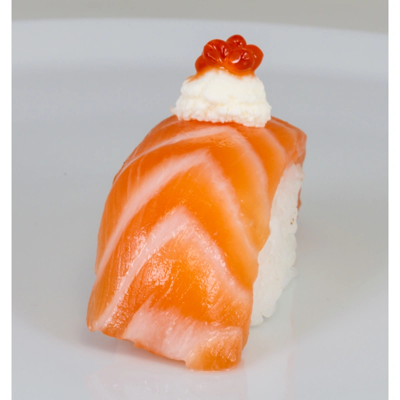 A single piece of sake sushi garnished with a dollop of cream cheese and a cluster of salmon roe on top, placed against a white background.