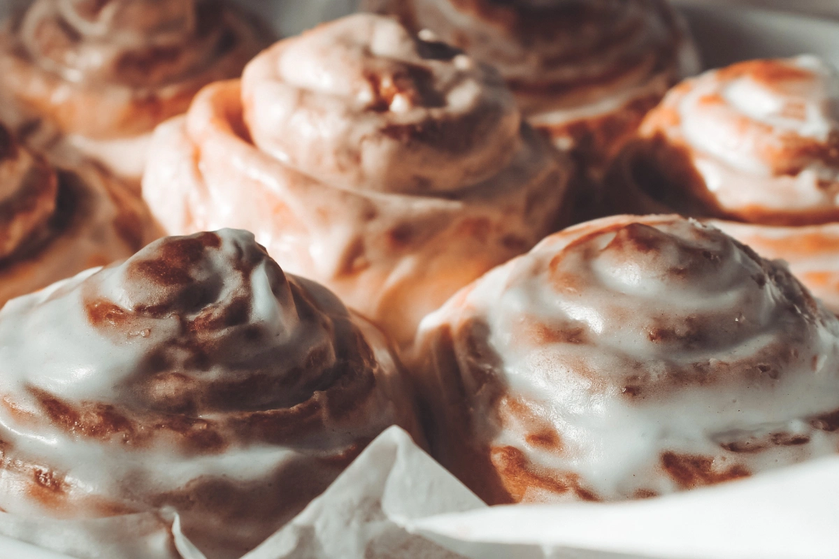 Close-up of freshly baked cinnamon rolls with white icing, titled "Air Fryer Cinnamon Rolls