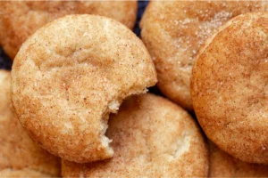 Close-up of cinnamon cookies sprinkled with sugar, with one cookie showing a bite taken out of it.