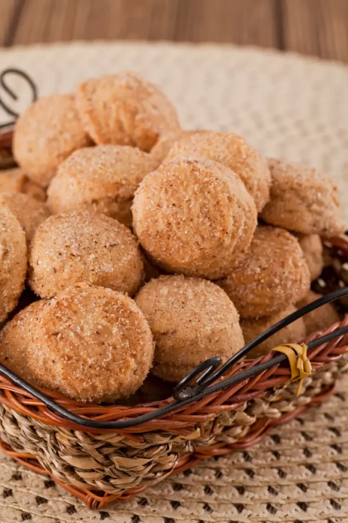 A basket of sugary Mexican cinnamon cookies on a burlap surface