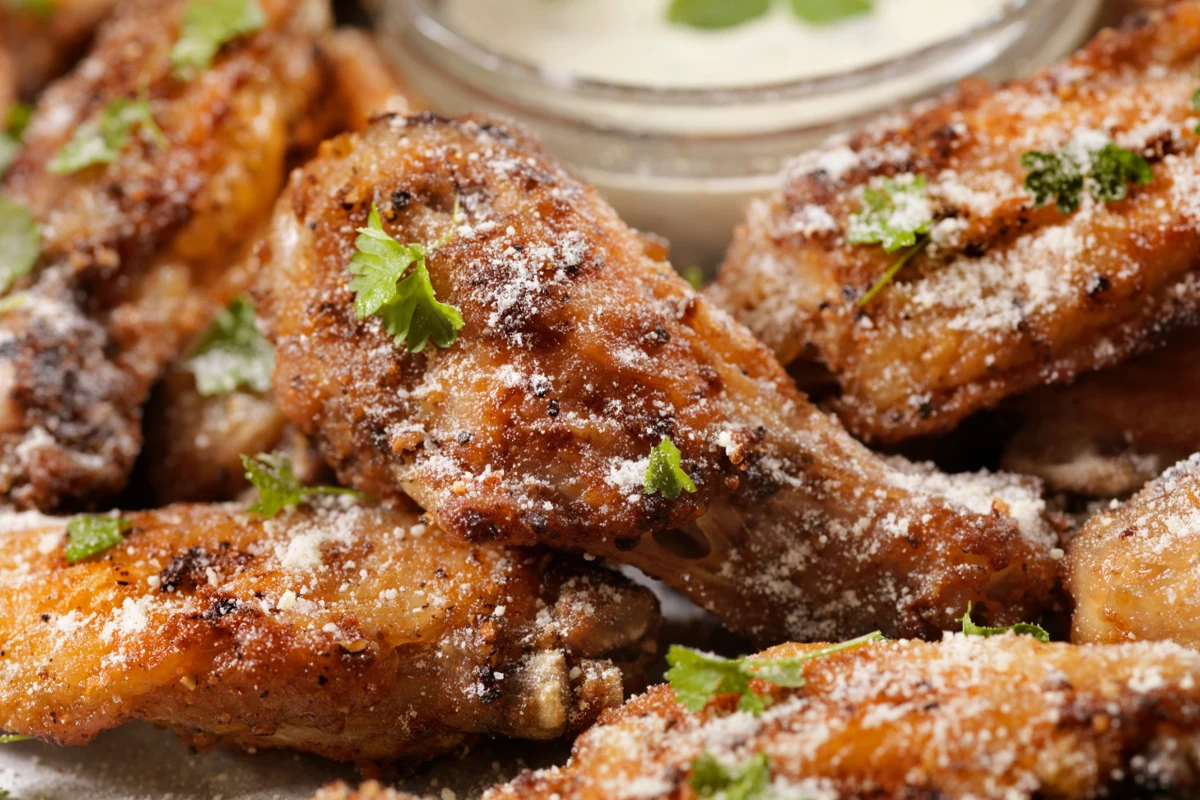 Close-up of garlic parmesan wings garnished with parsley.