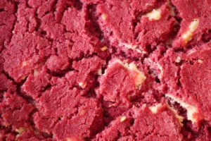 Close-up view of red velvet cookie with white chocolate chips scattered throughout.