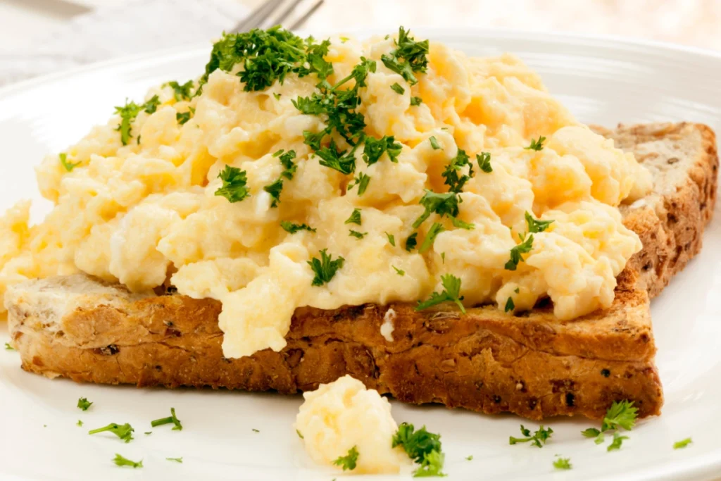 Scrambled eggs on toast garnished with parsley.