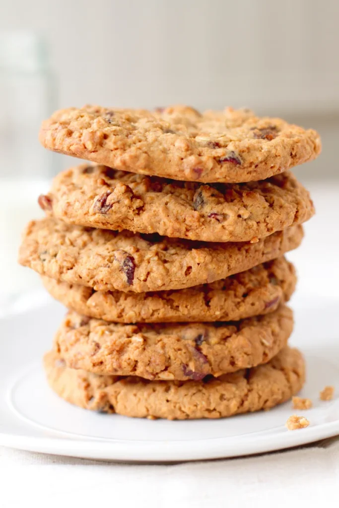 A stack of five cranberry and chocolate chip cake mix cookies on a white plate, with visible crumbs.