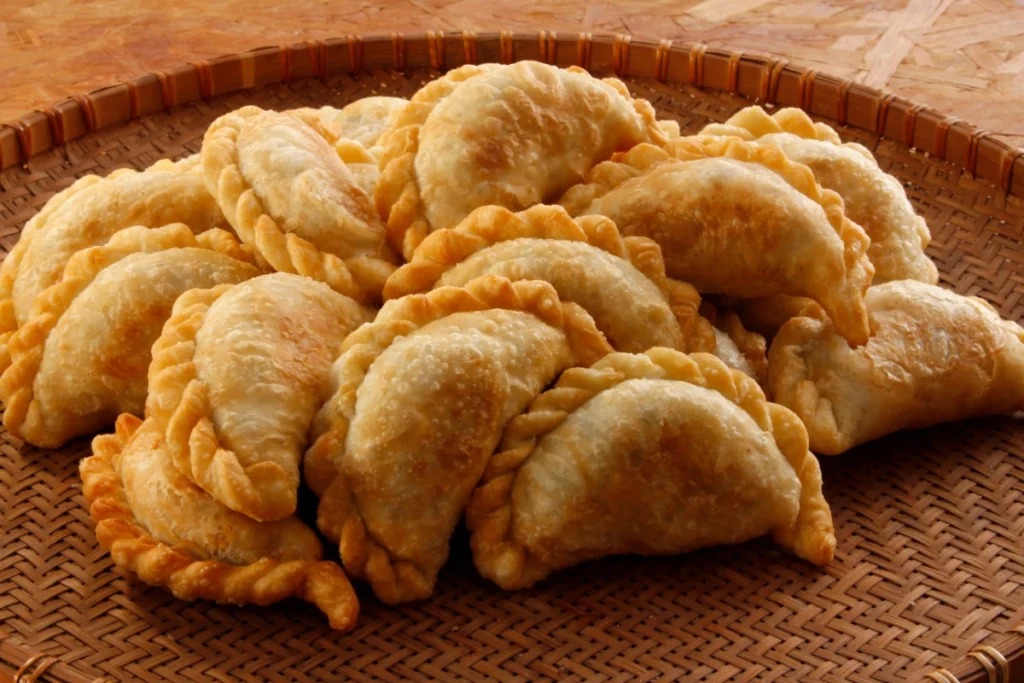 A basket filled with golden, crispy empanadas.