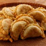 A basket filled with golden, crispy empanadas.